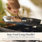 Hand lifting an Anolon EverLast stainless steel skillet by its bronze stay-cool long handle over a gas stove